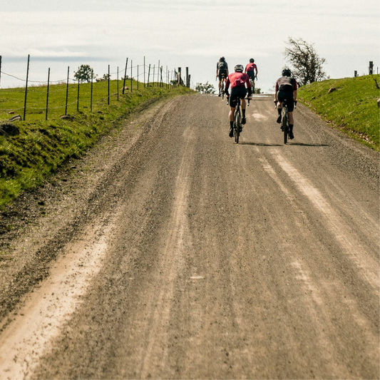Group of cyclists riding on a gravel road during a long-distance endurance ride, illustrating cycling comfort and the need for chamois cream like Velovaere.
