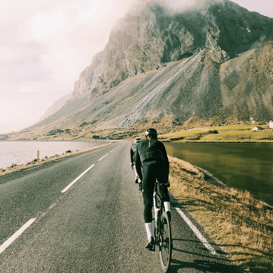Cyclists riding on a scenic mountain road during a long endurance ride — demonstrating the need for chamois cream to prevent chafing and saddle sores on long-distance rides.